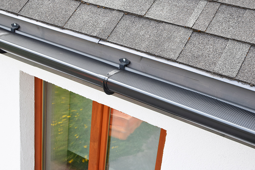 gutter guard over residential property with asphalt roofing